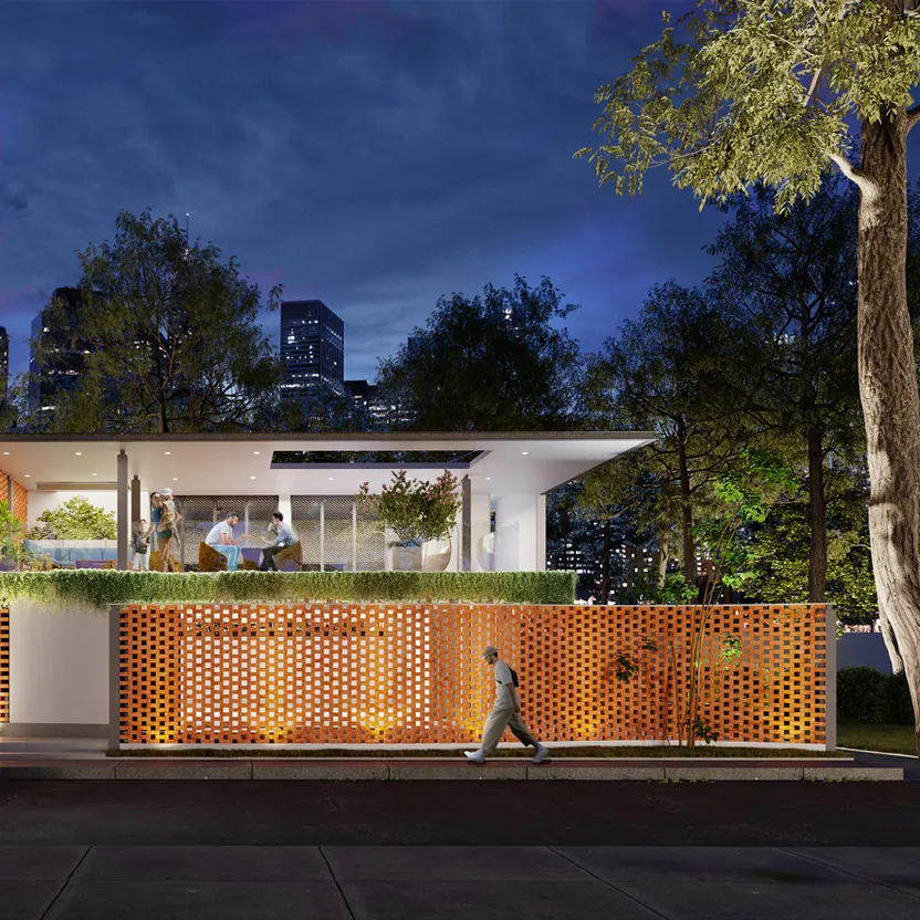 The clubhouse lit at dusk behind its brick screen wall